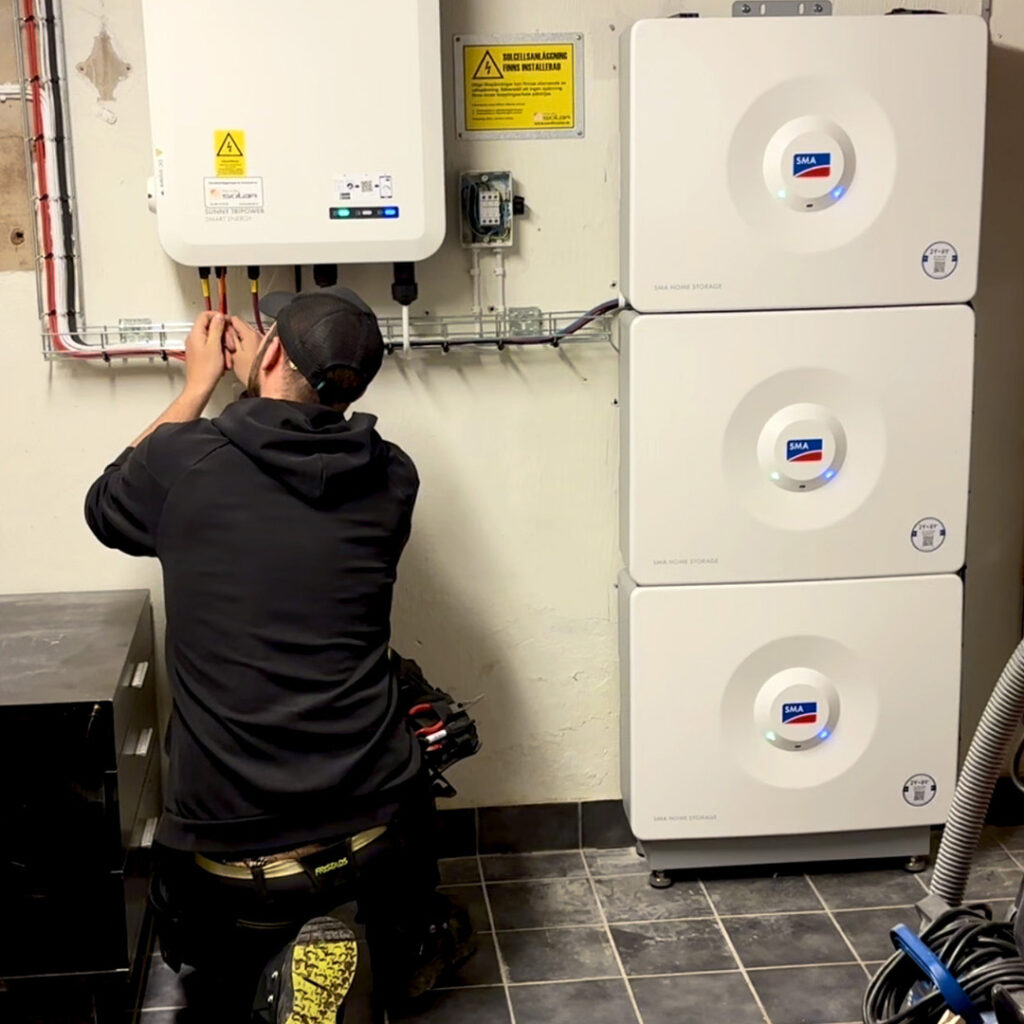 Elektriker installerar tre solcellsbatterier från SMA och en växelriktare från SMA.