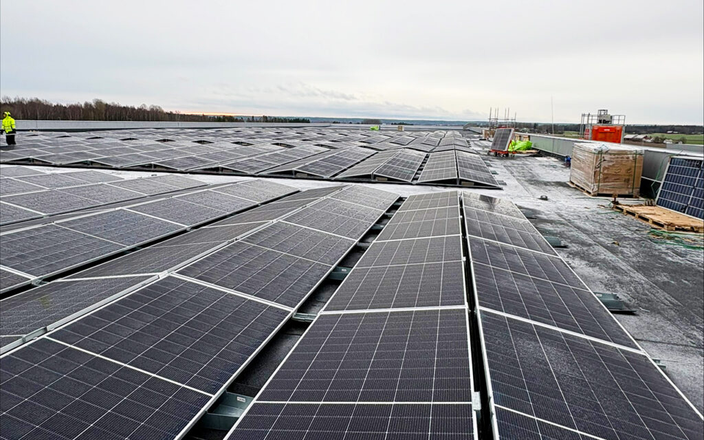 Solpaneler installerade av Nordic Solar på taket vid Solar Sveriges logistikcentrum, en omfattande solcellsanläggning som producerar förnybar energi.
