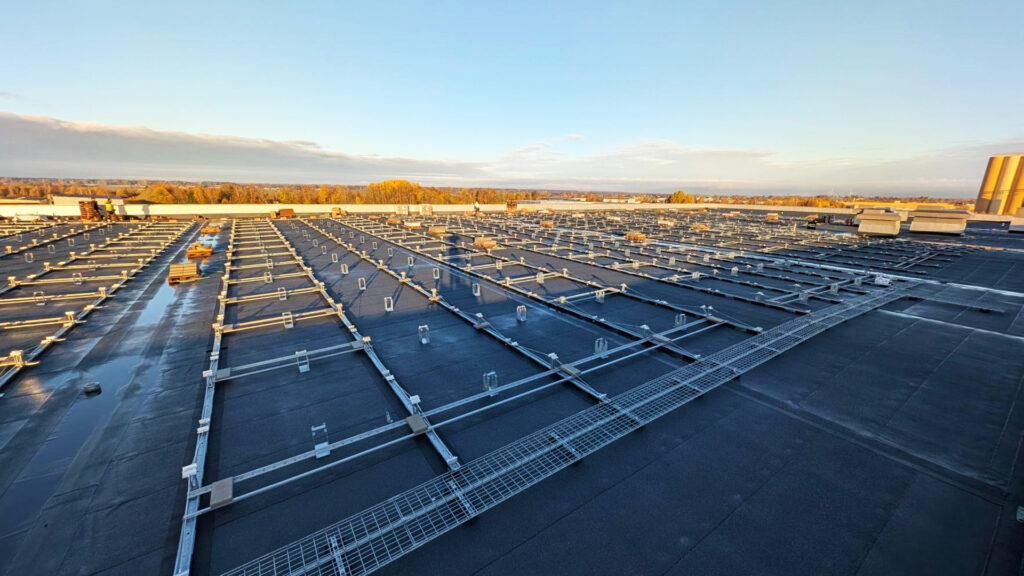 Underkonstruktion för solpaneler monteras på taket vid Solar Sveriges logistikcentrum, som förberedelse för en omfattande solcellsanläggning.