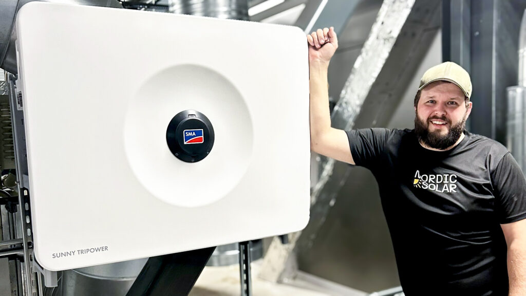 Emil, elektriker på Nordic Solar, arbetar med installation av solcellsanläggning.